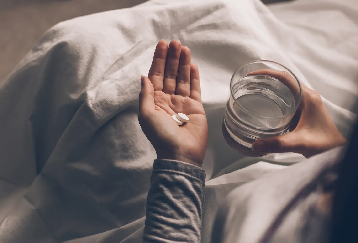 hand holding melatonin pills